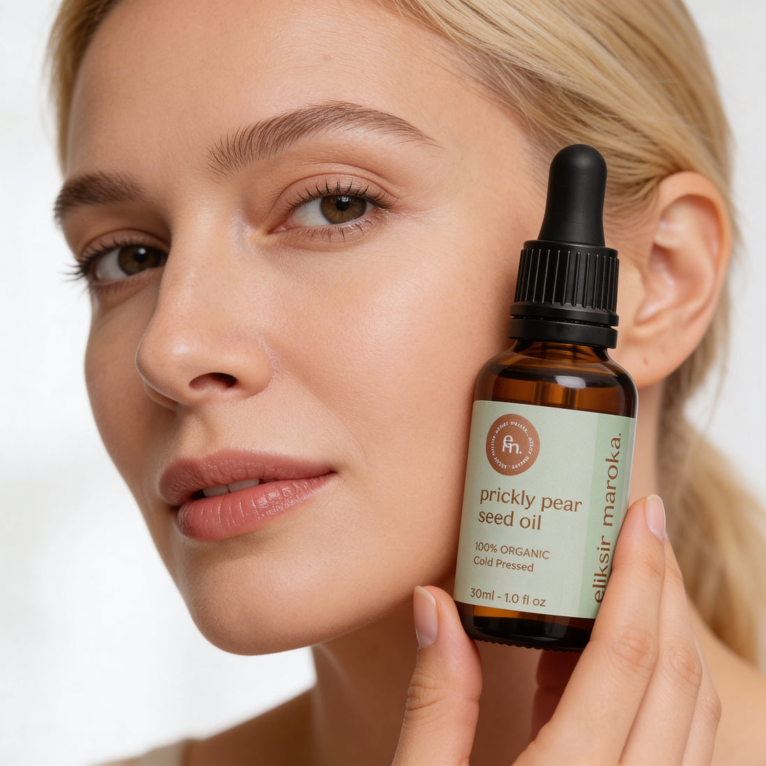 Kobieta aplikująca naturalne serum do cery naczynkowej z opuncji figowej Eliksir Maroka łagodzące rumień.