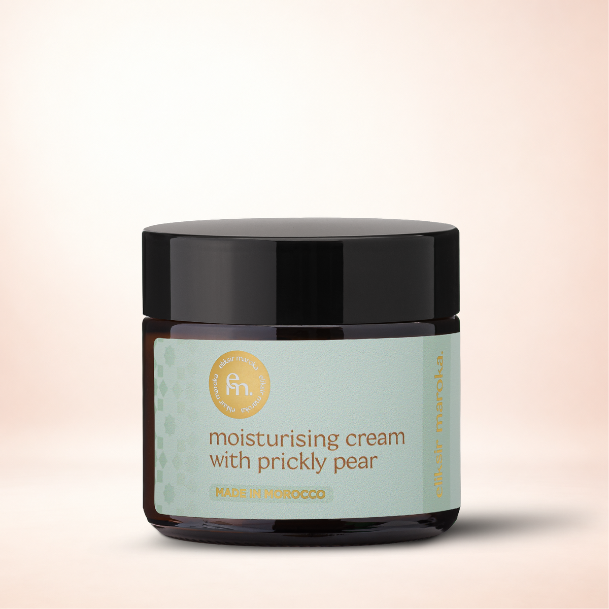 Round dark glass jar with a black lid and light green label reading moisturising cream with prickly pear eliksir maroka.