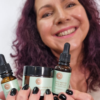 Uśmiechnięta klientka polecająca z bliska kompletny zestaw z opuncją figową EliksirMaroka: 100% naturalne serum przeciwzmarszczkowe, krem nawilżający i olejek. | Smiling customer recommending up close the complete EliksirMaroka prickly pear set: 100% natural anti-ageing serum, moisturising cream, and oil.